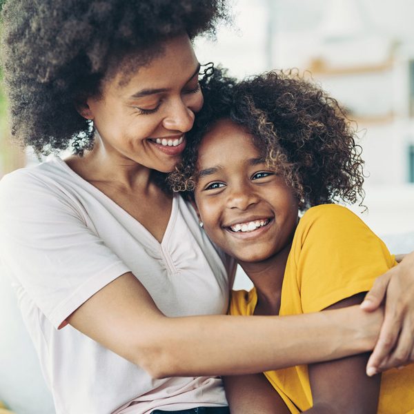 Smiling mother lovingly holding her daughter Happy family